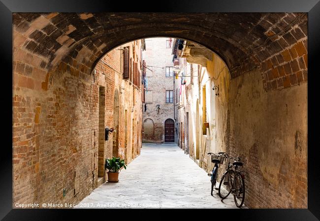 View of an alley in a Tuscan town Framed Print by Marco Bicci