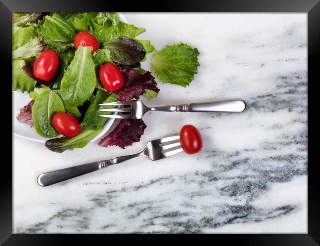 Healthy organic salad flowing out of plate  Framed Print by Thomas Baker