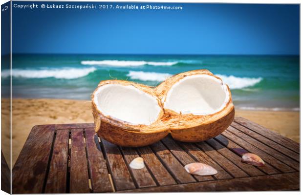 Coconut on the table against beautiful beach Canvas Print by Łukasz Szczepański