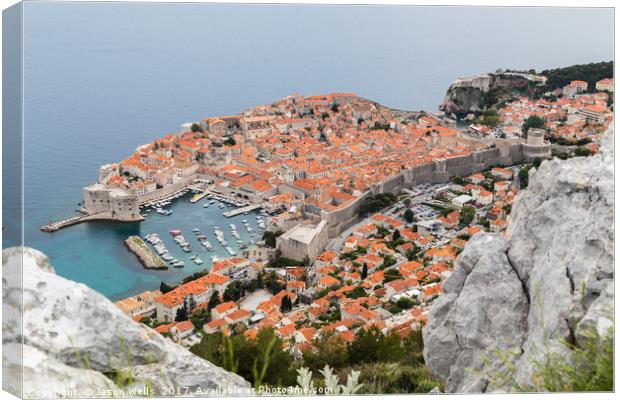 Dubrovnik seen between the rocks on Srd hill Canvas Print by Jason Wells