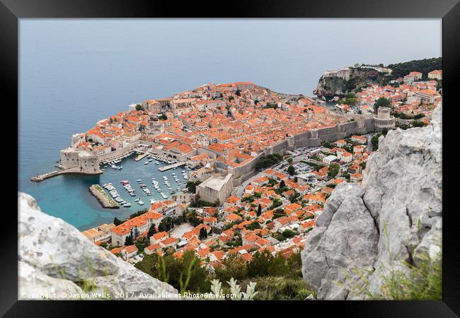 Dubrovnik seen between the rocks on Srd hill Framed Print by Jason Wells