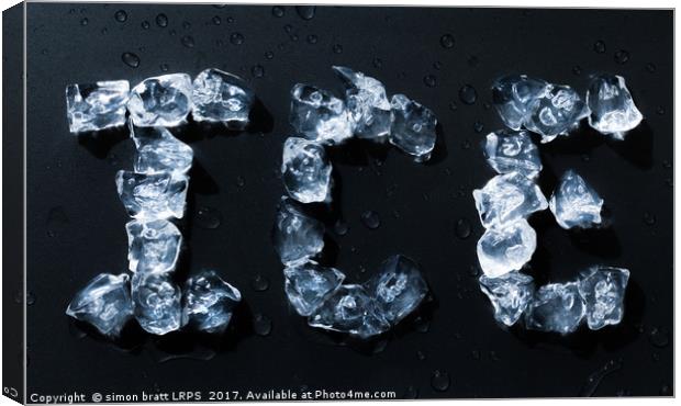 Ice written with ice cubes on dark background Canvas Print by Simon Bratt LRPS