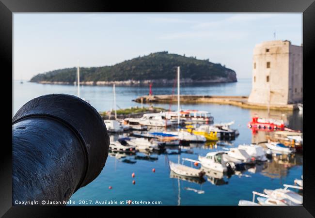 Cannon faces out over the harbour Framed Print by Jason Wells