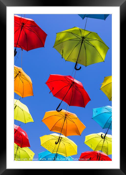 Suspended umbrellas swaying in the wind Framed Mounted Print by Jason Wells