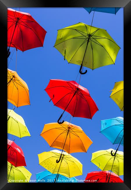 Suspended umbrellas swaying in the wind Framed Print by Jason Wells