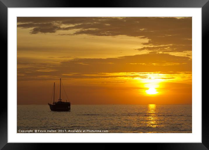 Boat silhouette at sunset Framed Mounted Print by Kevin Hellon