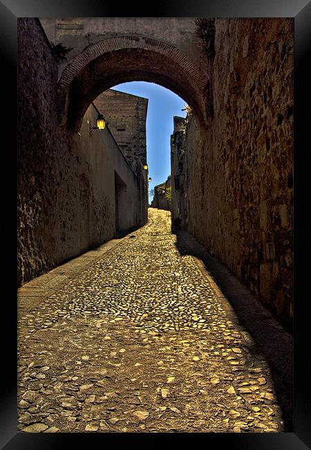 Old arch over narrow street in Caceres Framed Print by Gabor Pozsgai