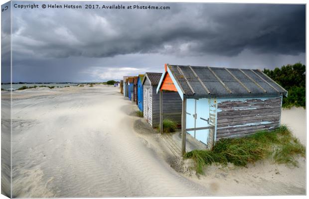 Beach Huts Under A Stormy Sky Canvas Print by Helen Hotson