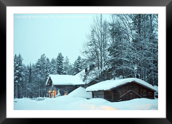 Log cabins nestled in the snow laden trees at dusk Framed Mounted Print by Teresa Cooper