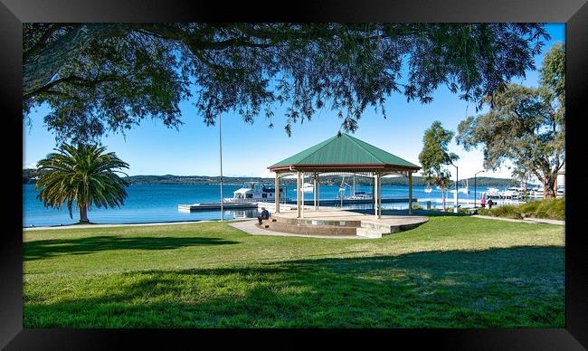  Lush green grassy waterfront park with a quaint l Framed Print by Geoff Childs