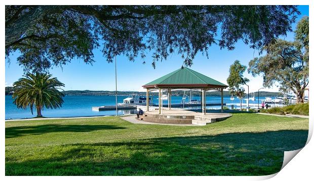  Lush green grassy waterfront park with a quaint l Print by Geoff Childs