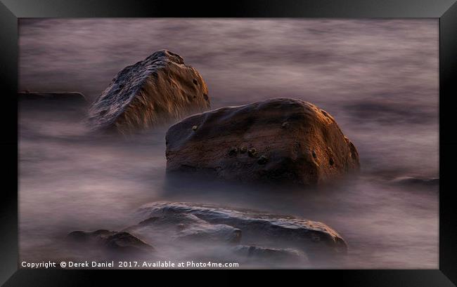 Moving water around rocks in Kimmeridge Bay Framed Print by Derek Daniel