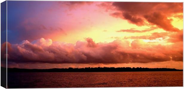 Cloud bank highlighted sunset seascape.  Canvas Print by Geoff Childs