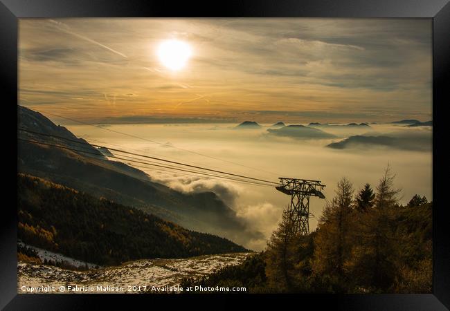 The sun sets over a sea of clouds Framed Print by Fabrizio Malisan