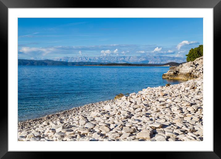 Overlooking the pebbles of Vaja Bay Framed Mounted Print by Jason Wells