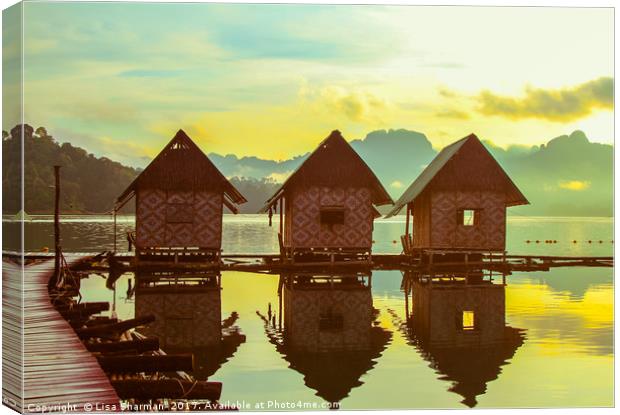 Sun rising over cute little wooden huts perched on Canvas Print by  
