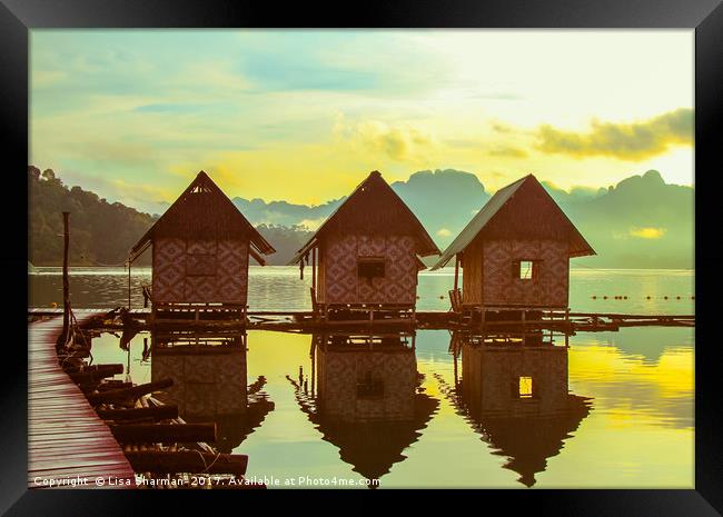 Sun rising over cute little wooden huts perched on Framed Print by  