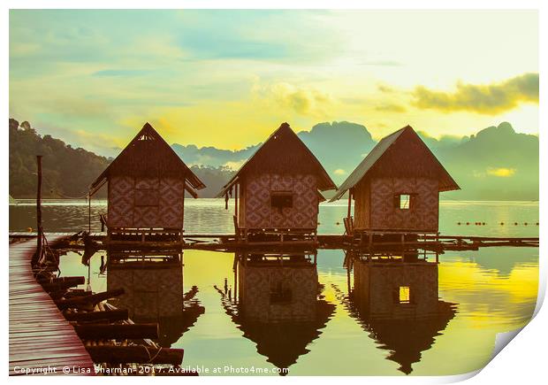 Sun rising over cute little wooden huts perched on Print by  