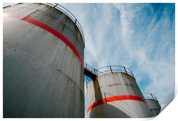 Industrial fuel tanks against a blue sky Print by Tom Radford