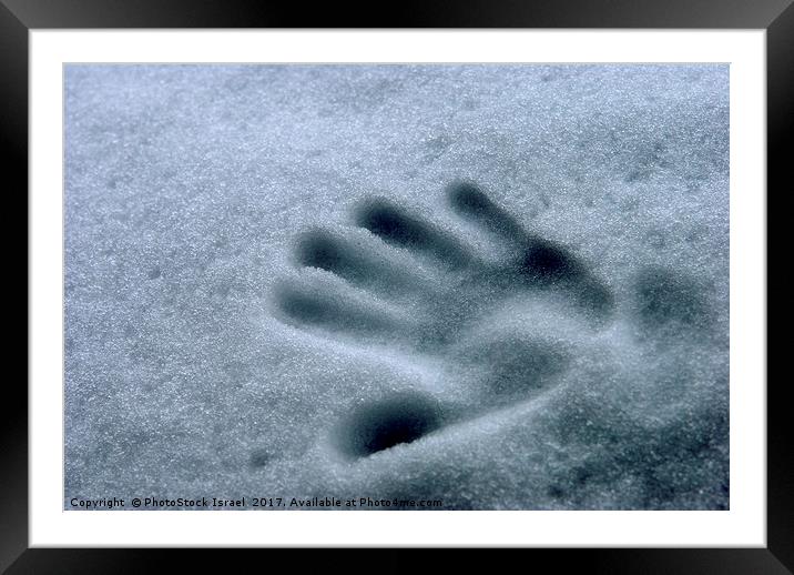 Imprint of a young child's hand in snow Framed Mounted Print by PhotoStock Israel