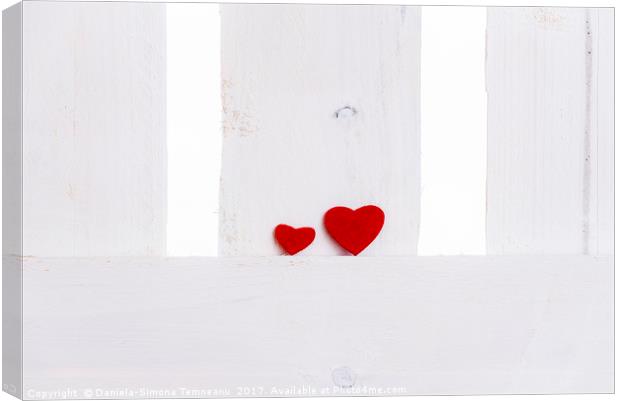 Big and small red hearts on a fence Canvas Print by Daniela Simona Temneanu