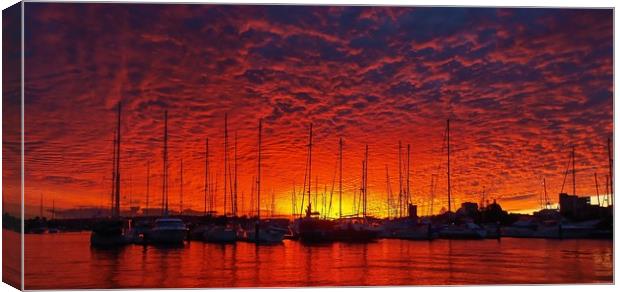 Vibrant red colored cloudy sunset seascape.   Canvas Print by Geoff Childs