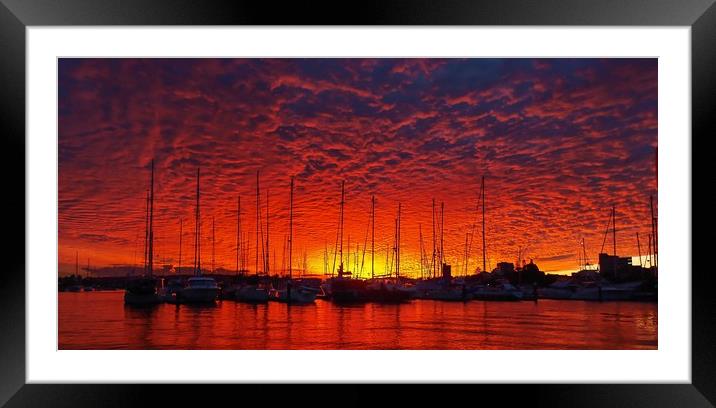 Vibrant red colored cloudy sunset seascape.   Framed Mounted Print by Geoff Childs