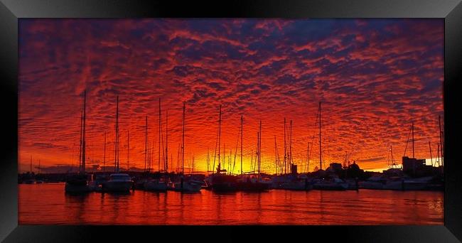 Vibrant red colored cloudy sunset seascape.   Framed Print by Geoff Childs