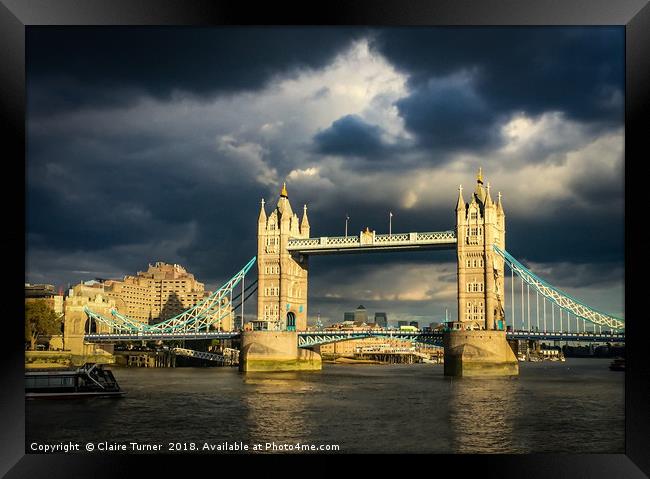 Tower bridge illuminated in a dark sky Framed Print by Claire Turner