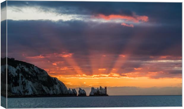 Red starburst sunset behind the Needles rocks Canvas Print by Alf Damp