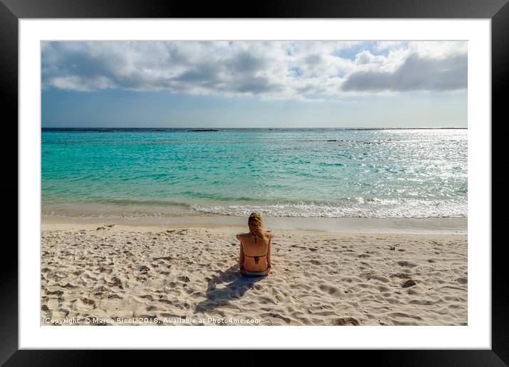 Woman relax in front of the Caribbean Sea in Aruba Framed Mounted Print by Marco Bicci