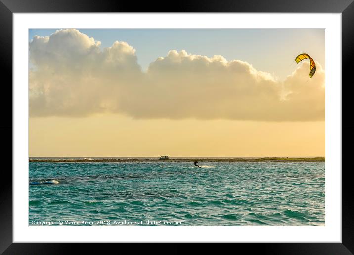 A man practices kitesurfing at sunset Framed Mounted Print by Marco Bicci