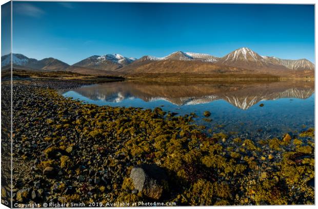 Snow capped Red Cuillin hills reflected. Canvas Print by Richard Smith
