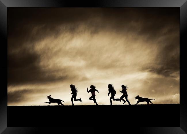  Silhouettes of running Girls and Dogs  Framed Print by Maggie McCall