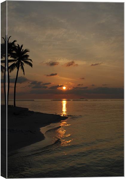Sun setting behind clouds - Maldives Canvas Print by Madeline Harris
