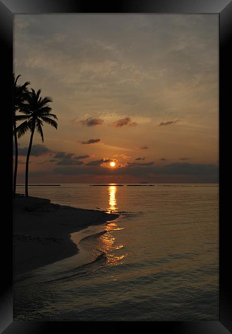 Sun setting behind clouds - Maldives Framed Print by Madeline Harris