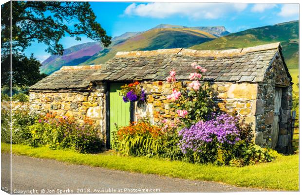 Flowers and stone hut with Blencathra behind Canvas Print by Jon Sparks