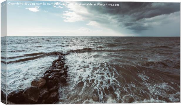 Rocks in the sea with storm sky on the beach Canvas Print by Juan Ramón Ramos Rivero