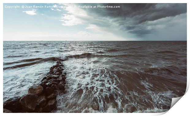 Rocks in the sea with storm sky on the beach Print by Juan Ramón Ramos Rivero