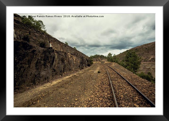 Old train tracks between mountains on a cloudy day Framed Mounted Print by Juan Ramón Ramos Rivero