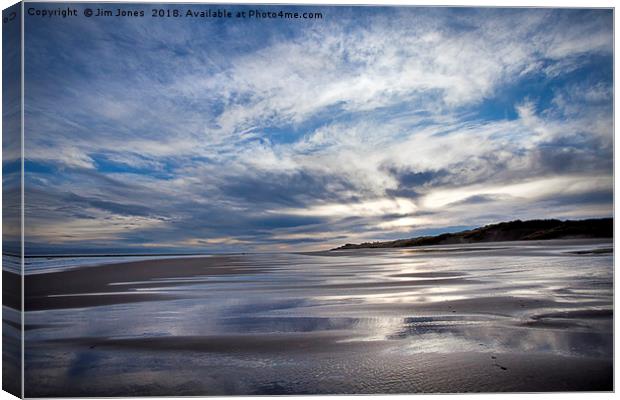 Cloudy blue sky reflected in the wet sand at Druri Canvas Print by Jim Jones