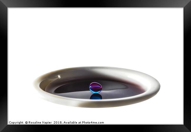 Colourful water droplet balancing on cup of water Framed Print by Rosaline Napier