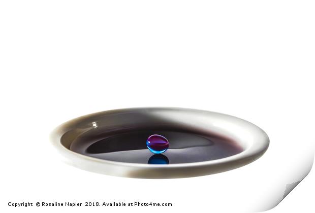 Colourful water droplet balancing on cup of water Print by Rosaline Napier