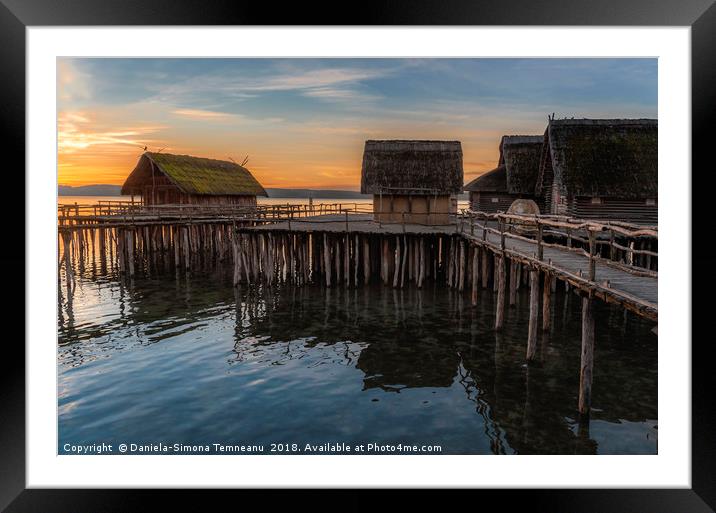 Old wooden cabins over water at sunset Framed Mounted Print by Daniela Simona Temneanu