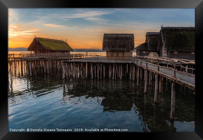 Old wooden cabins over water at sunset Framed Print by Daniela Simona Temneanu