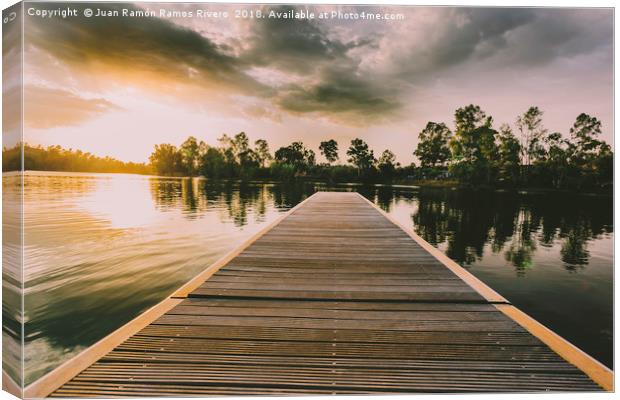 Wooden jetty over the lake at sunset in a sky with Canvas Print by Juan Ramón Ramos Rivero
