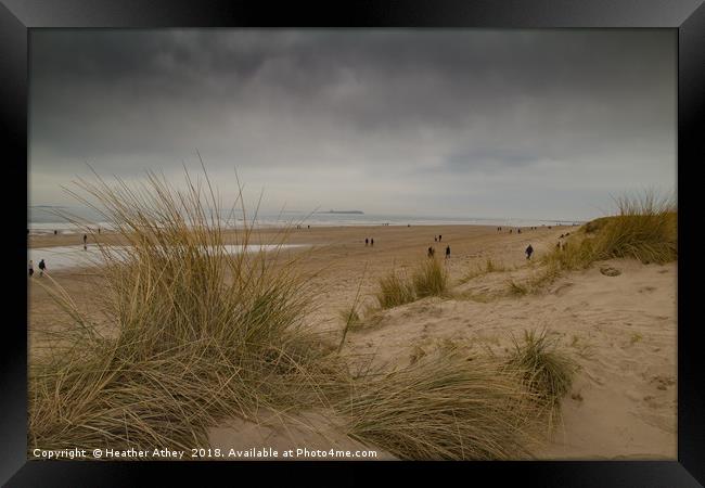 Moody day at Bamburgh beach, Northumberland Framed Print by Heather Athey