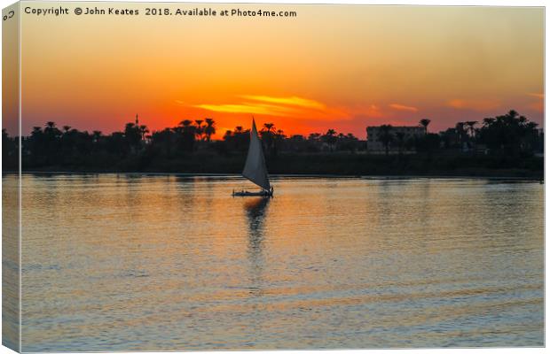 Sunset on the Nile River with Felucca boat sailing Canvas Print by John Keates
