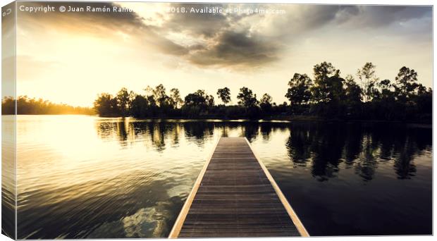 Wooden jetty over the lake with reflections Canvas Print by Juan Ramón Ramos Rivero