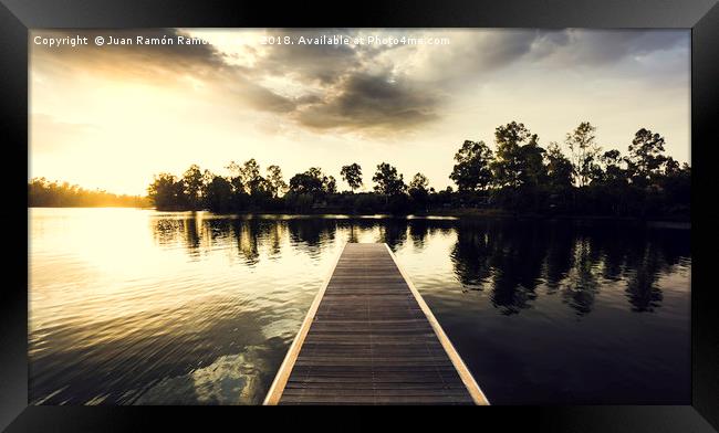 Wooden jetty over the lake with reflections Framed Print by Juan Ramón Ramos Rivero